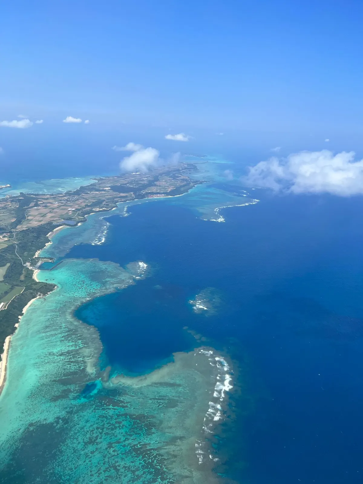 上空から見た、浅瀬に囲まれた島と海岸線